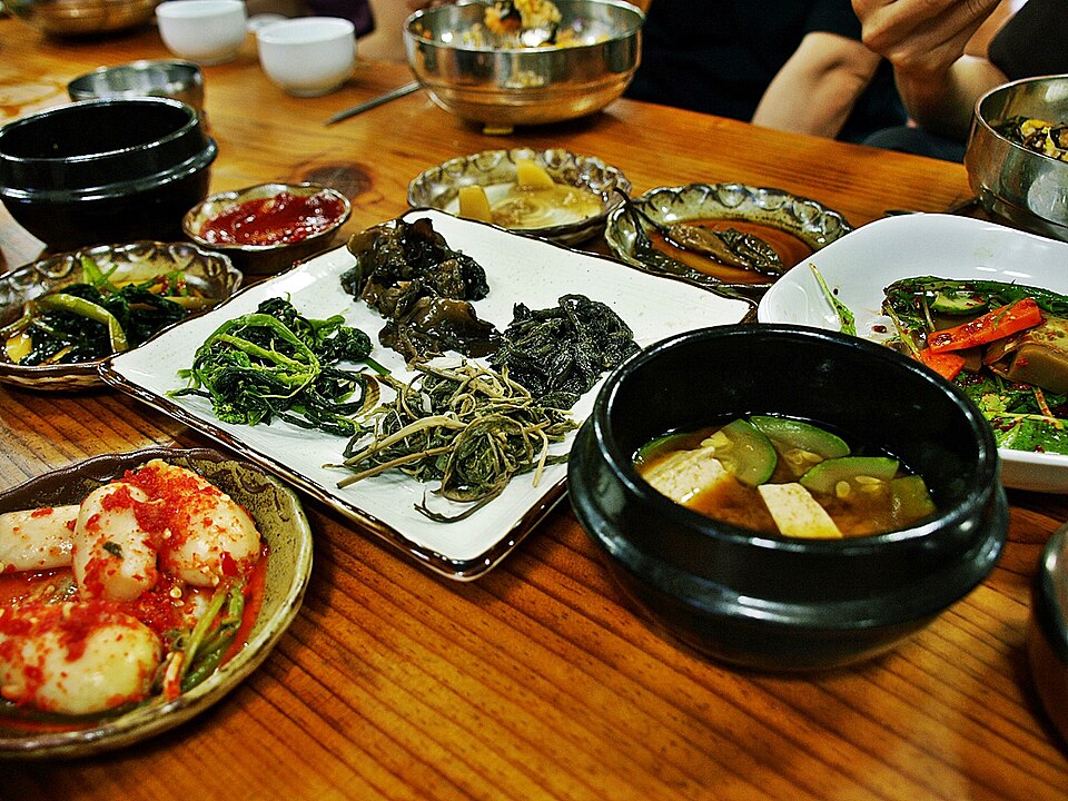 Korean doenjang jjigae with banchan side dishes on a table